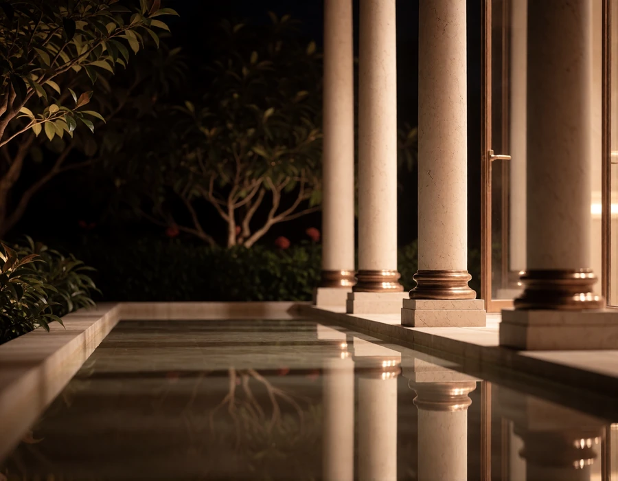 Stone courtyard with a shallow reflecting pool and warm uplit columns in the Houston Museum District at night