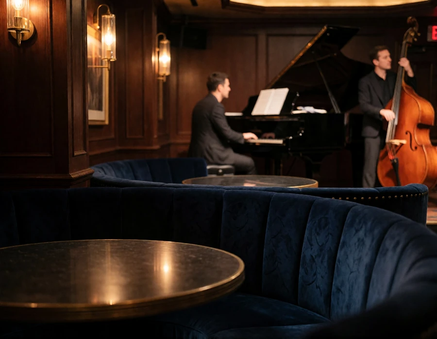 Intimate live-music lounge in Atlanta with a piano stage and velvet seating under warm spotlights