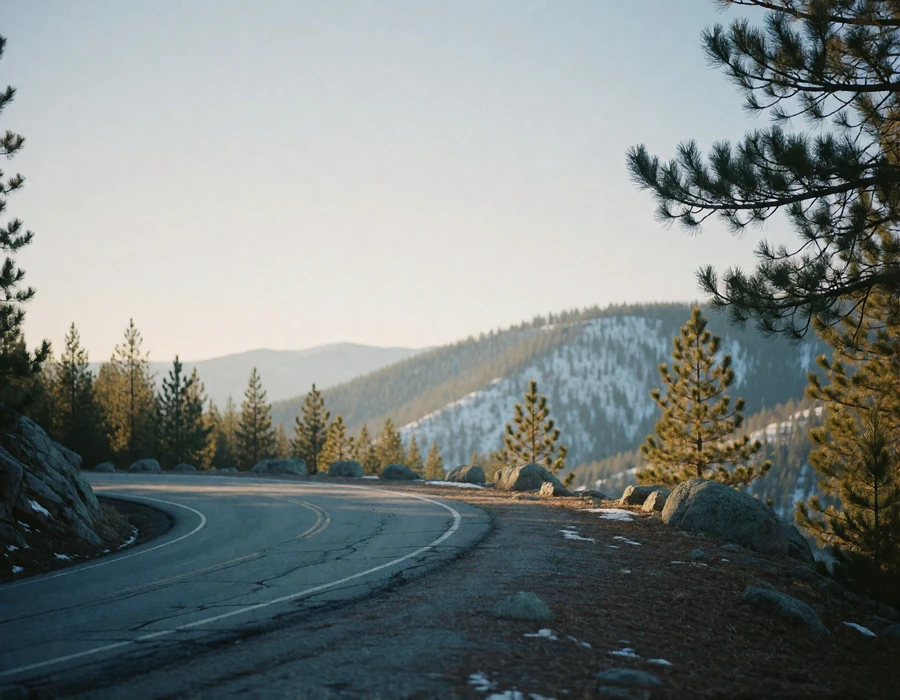 Winding mountain road curving toward a high overlook above a pine-covered valley near Denver