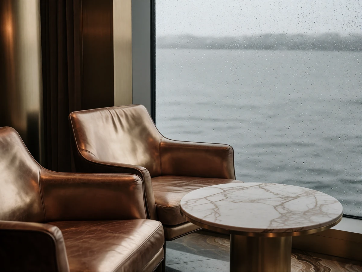 Refined harbor-view lounge with leather armchairs beside a rain-streaked window, a setting typical of quiet Seattle introductions